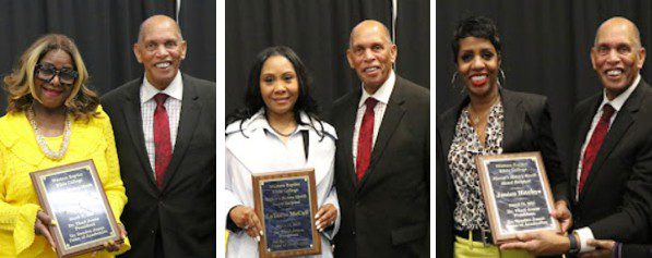 Three women receiving awards with a man.